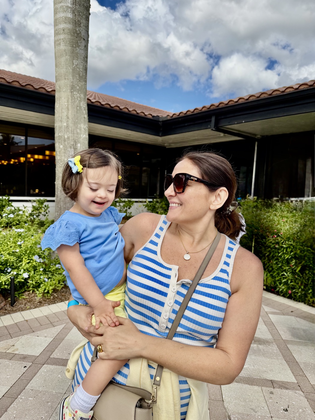Founder Erica Corsano smiling as she holds her daughter Isabella outdoors