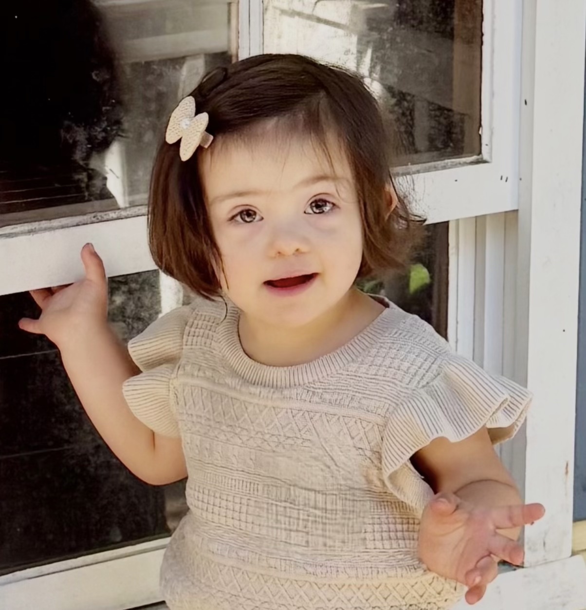Isabella, lovingly known as Pom Pom, smiling by a window